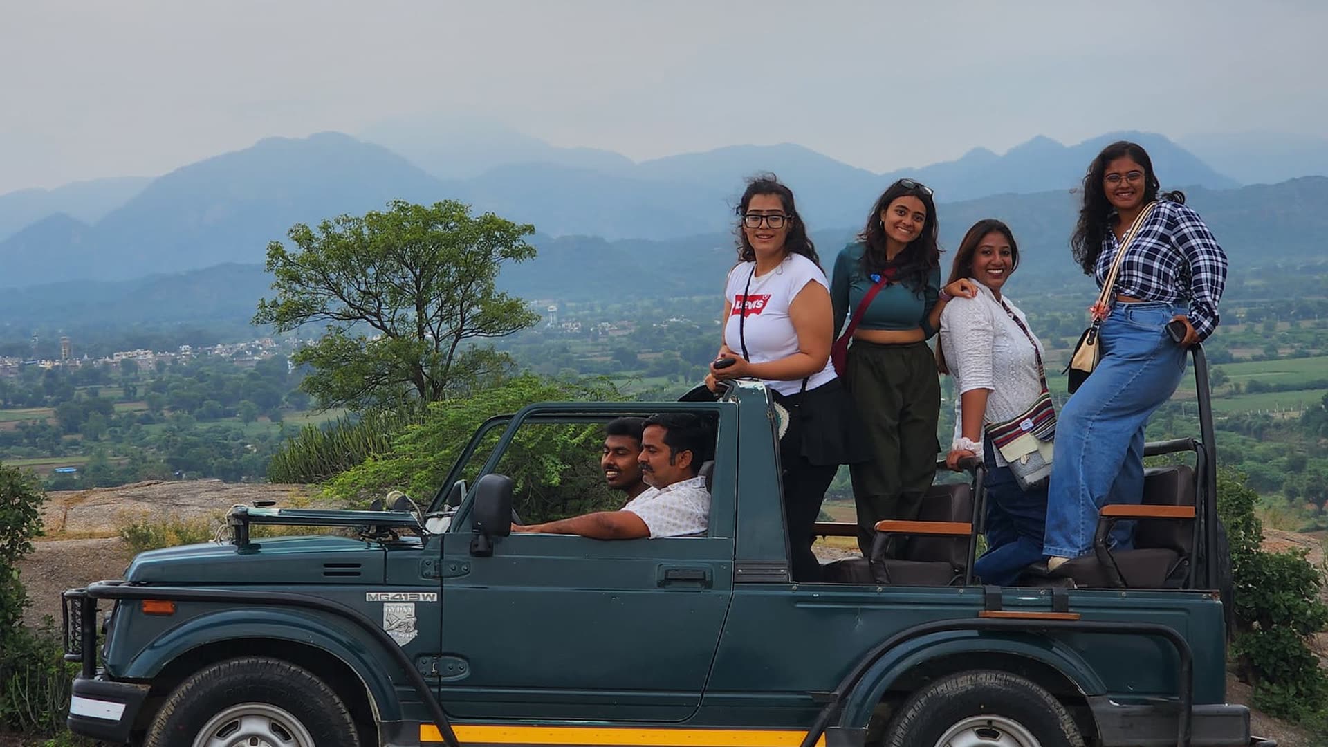Gujarat Adventure Club travellers on a group trip jeep with hills behind them